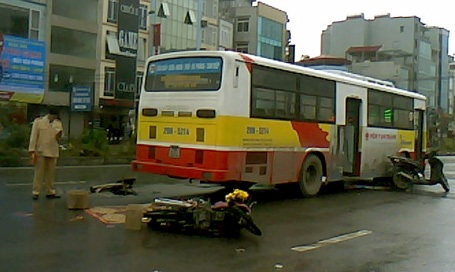 Hà Nội: Ngã ra đường, cô gái bị xe buýt cán tử vong - 2 Chiếc xe buýt đỗ ngay sát xác nạn nhân và chiếc hố ga mất nắp.