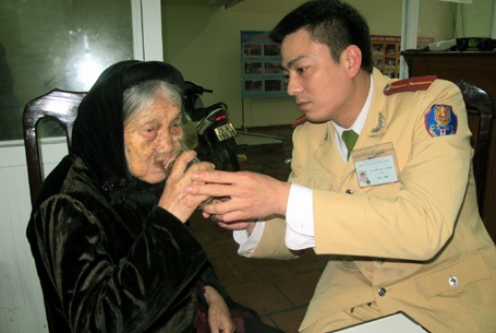 Hà Nội: CSGT tìm người thân giúp cụ già 91 tuổi lạc dưới mưa - 1 Thiếu úy Nguyễn Hiếu Minh chăm sóc cụ Lê tại trụ sở Đội CSGT số 2, chờ tìm lại nhà cho cụ.