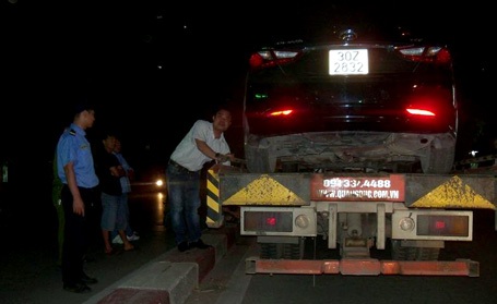 Chiếc xế hộp bị nạn được đưa lên xe cứu hộ.