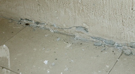 Nhiều vết nứt chạy dọc trụ tường và dưới chân tường.