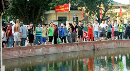 Hà Nội: Xác người phụ nữ nổi trên mặt hồ giữa làng - 1 Người dân hiếu kỳ tụ tập quanh khu vực phát hiện xác nạn nhân.
