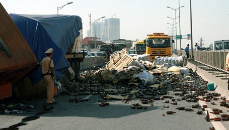 Hà Nội: Xe rơ-moóc lật nghiêng, hàng nghìn chai bia tràn ra đường - 3 Hàng ngàn vỏ chai bia bịt kín toàn bộ một chiều đường.