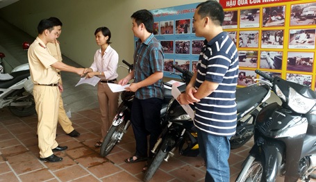 Hà Nội: Tìm được chiếc xe bị mất cắp 7 năm trước - 1 Đại diện Đội CSGT số 2 trao trả tài sản bị mất cho 3 người dân.