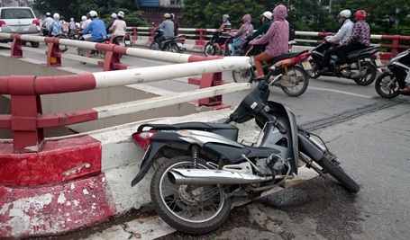 Thiếu nữ lái xe máy rơi từ cầu Chương Dương xuống đất - 1 Chiếc xe máy nằm lại trên cầu, trong khi chủ nhân rơi xuống dưới.