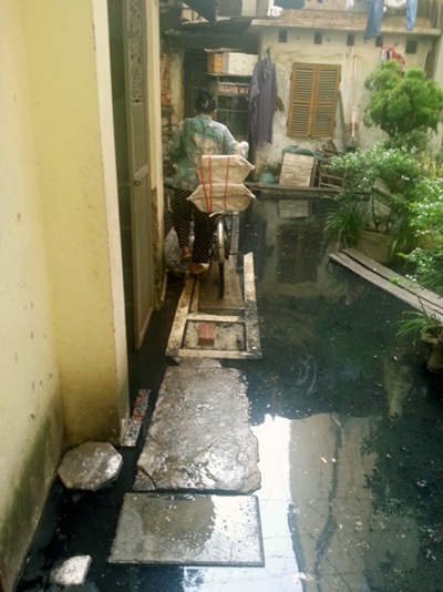 Hà Nội: Sống cùng nước cống đen ngòm ngập sâu cả mét - 3 Mọi người phải bắc cầu để đi lại trong khu nhà.