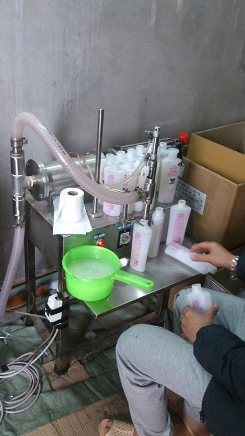 Đột kích cơ sở sản xuất sữa tắm, thu giữ hơn 7.000 chai sữa tắm "dởm" - 3 Công nhân ngồi đóng sản phẩm thủ công