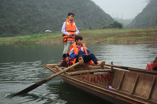 Chùm ảnh: Học sinh lớp 6 tự chèo thuyền đi học - 8 Một em học sinh lớp 7 dùng chân chèo thuyền làm người lái đò đưa các bạn của mình qua sông