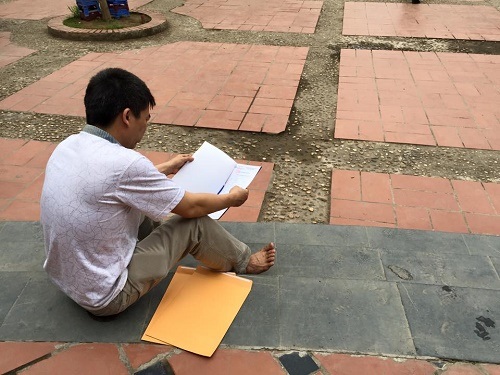 Phụ huynh ngồi ngâm cứu hồ sơ tuyển sinh lớp 6