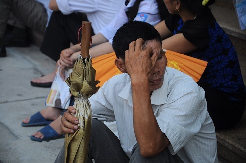 Một phụ huynh lo lắng chờ con ra khỏi phòng thi