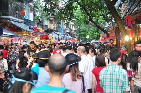 Một nữ du khách người Pháp rất quan tâm tới những mặt nạ giấy bồi tại Hàng Mã.