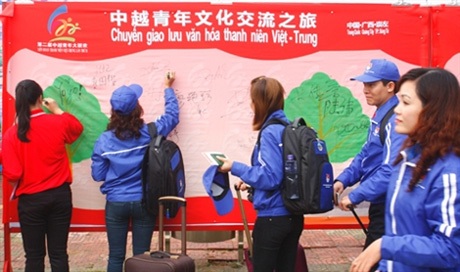 Thanh niên Việt Nam ký tên vào dải lụa hồng lưu dấu tình hữu nghị giữa tuổi trẻ hai nước.