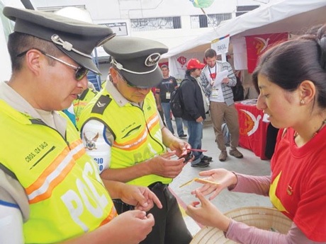 Người con tha hương trước gian hàng Việt ở Ecuador - 3 Carcelen hướng dẫn hai cảnh sát cách đặt con chuồn tre đậu lên ngón tay.