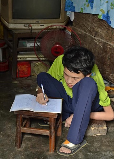 Ước mơ lớn trong những căn nhà nhỏ… - 1 Dưới cái nắng gay gắt của mùa hè, em Kiệt ngồi nghiêng ngả bên một vách tường để học bài