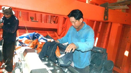 Chuyện vươn khơi “của hai cậu cháu” - 2 Ngư dân Võ Công Thảo lau chùi máy chính của tàu cá