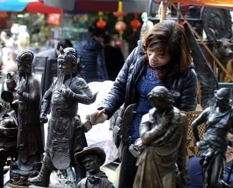 Người bán hàng làm sạch tượng Quan Công.