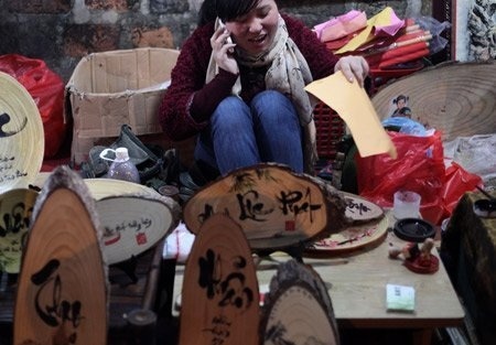 Phố "ông Đồ" thời công nghệ số - 10 Dù là khách hàng hay chủ quán chữ, cứ rảnh rỗi lại dán mắt vào màn hình chiếc điện thoại cảm ứng.