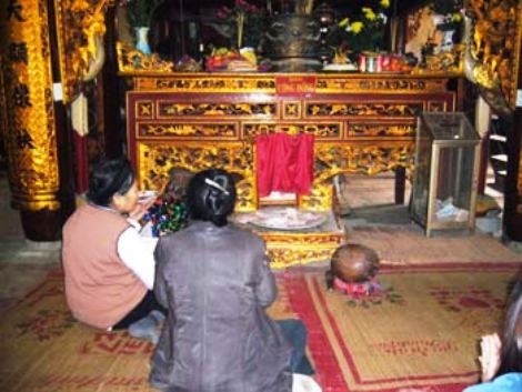 Nghề khấn thuê - 1 Khách đi lễ chùa đang nhờ người khấn hộ trước ban cộng đồng.