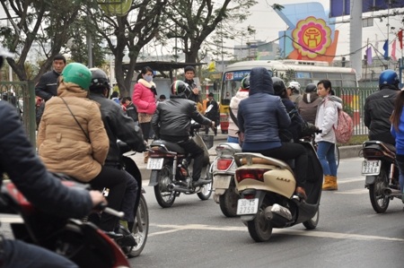 Các xe máy buộc phải dừng lại cho đoàn người đi qua