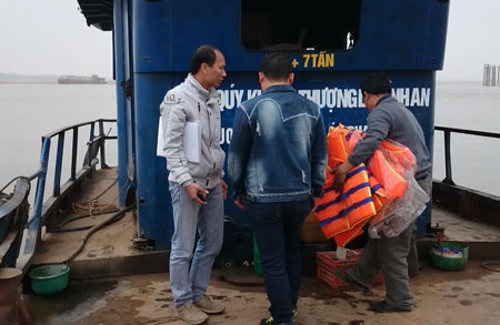 Hà Nội: Chủ đò ngang “đánh cược” tính mạng hành khách qua sông Hồng - 2 Khi cán bộ cơ quan chức năng (áo trắng) kiểm tra chủ đò mới mang áo phao ra