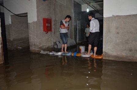 Công nhân bơm nước trong thang máy dưới tầng hầm