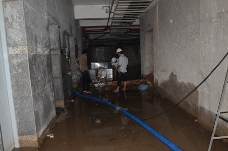 Công nhân bơm nước trong thang máy dưới tầng hầm