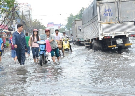 Lội xuống đường ngập bắt khách