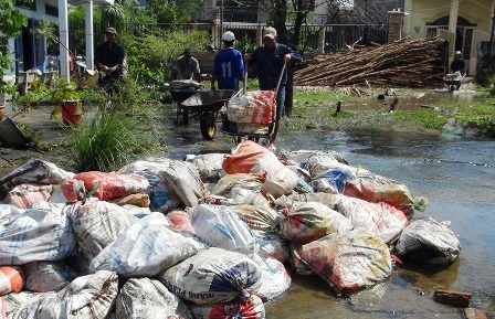 Huy động người dân chở bao cát để đắp lại khu vực bờ bao bị bể