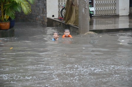 Trẻ nhỏ bơi lội trong dòng nước ngập