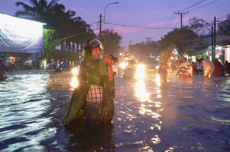 Một phóng viên ngâm mình giữa biển nước để tác nghiệp