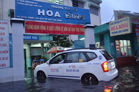 Nhiều phụ huynh phải thuê taxi để đón con vì đường ngập