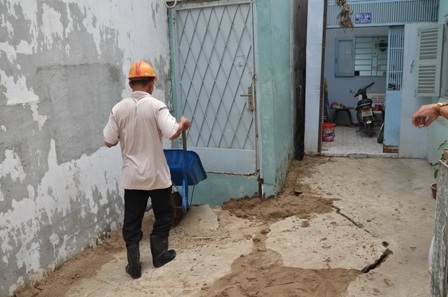 Công nhân đổ cát vào các vị trí nền nhà bị lún