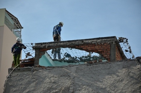 Từng mảng bê tông được đập bỏ