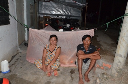 Vợ chồng bà Đặng Thị Huệ (49 tuổi) phải giăng mùng ngoài trời để ngù vì nhà đã ngập sâu hơn 1 mét