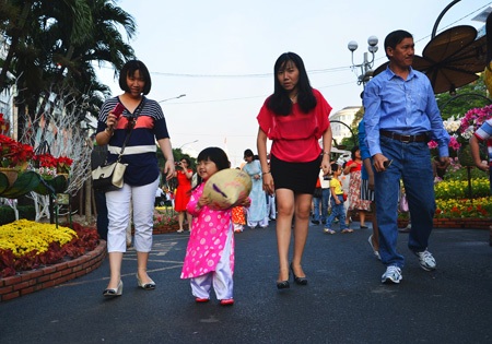 Người dân đổ về đường hoa Nguyễn Huệ sáng mùng 1 Tết - 2 Bé gái thích thú trong trang phục áo dài được mẹ dẫn đi dạo đường hoa