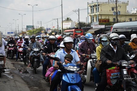 Dòng xe gắn máy xếp hàng di chuyển hướng về thành phố trên quốc lộ 1A đoạn qua huyện Bình Chánh