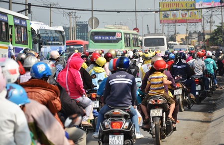 Dòng xe gắn máy xếp hàng di chuyển hướng về thành phố trên quốc lộ 1A đoạn qua huyện Bình Chánh