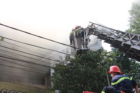 Các chiến sĩ sử dụng xe thang để tiếp cận đám cháy từ trên xuống