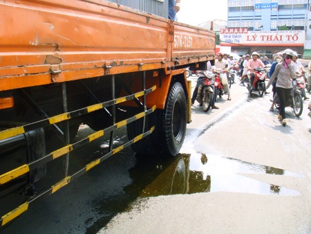 Nhiều người ngã vì nhớt từ xe tải chảy xuống đường - 1 Nhớt từ xe tải chảy xuống mặt đường khiến nhiều xe gắn máy lưu thông phía sau té ngã và phải dẫn bộ