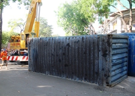 Một xe cẩu được điều đến hiện trường để di chuyển thùng container đi