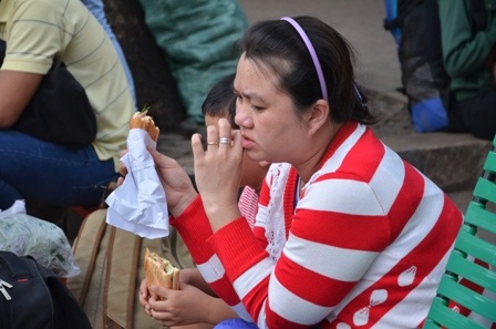 Mệt mỏi sau chuyến đi dài nên một hành khách phải ăn tạm ổ bánh mì