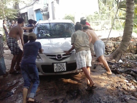 Hà Nội: Xế hộp lao từ hầm gửi xe, đâm thẳng vào nhà dân - 5 Người dân phụ đẩy chiếc xe gặp nạn lên bờ.