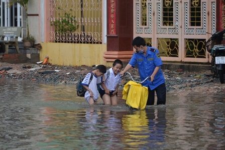 Hai em học sinh tiểu học thích thú với cảnh ngập nước giữa Sài Gòn