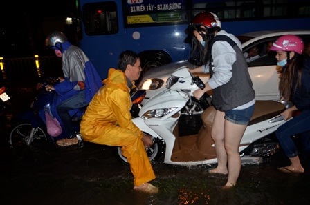 Nhân viên thoát nước giúp người dân đưa xe qua vùng ngập