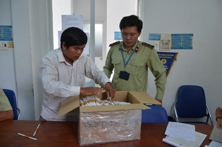 Ông Trung (áo trắng) cùng số thuốc lá giả bị bắt giữ