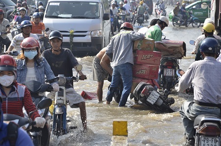 Một thanh niên bị ướt hết hàng hóa do té xe