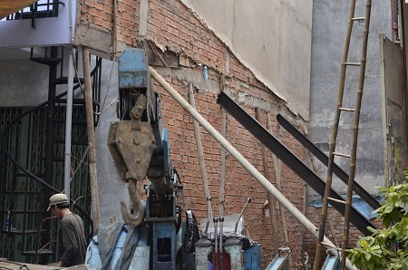 Lực lượng chức năng đã phải dùng cọc sắt chống hai bên để tránh nguy cơ ngôi nhà đổ sập