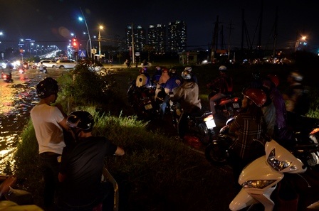 Nhiều người không dám lưu thông qua vùng ngập mà phải ngồi chờ nước rút mới về nhà