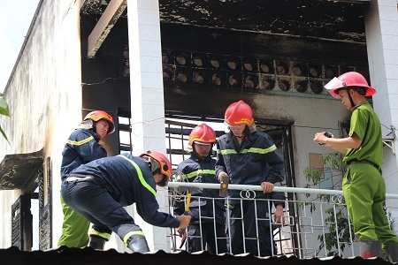 Lực lượng chức năng phá mái tôn để khói thoát ra ngoài