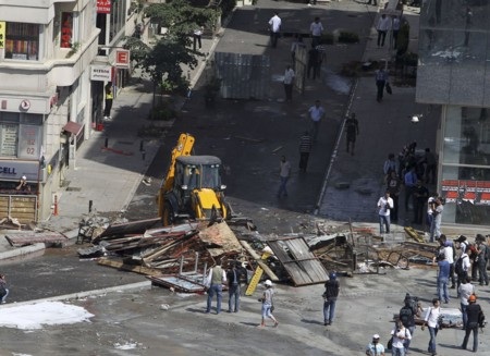 Xe ủi của lực lượng chức năng phá rào chắn của người biểu tình