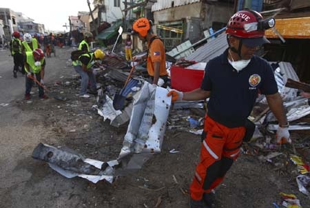 Một tuần sau bão, người Philippines bắt tay dựng lại nhà cửa - 1 Người dân và các lực lượng cứu trợ tích cực dọn dẹp tại Guiuan
